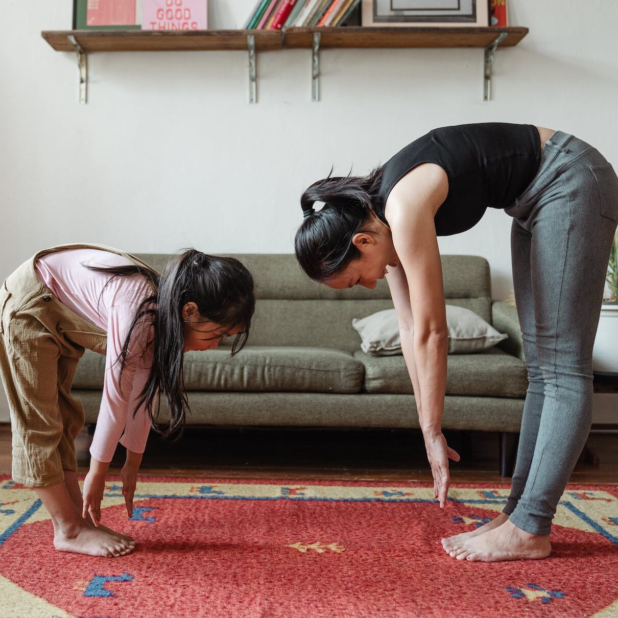 photo of woman and girl stretching their body